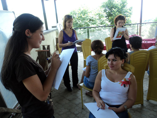 Девушки за работой - кто-то рисует глаза, кто-то подбородок, кто-то волосы и/или уши...