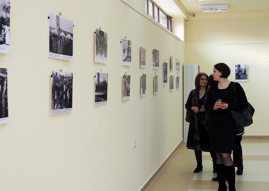 Посетители рассматривают фотографии. Посетители рассматривают фотографии.