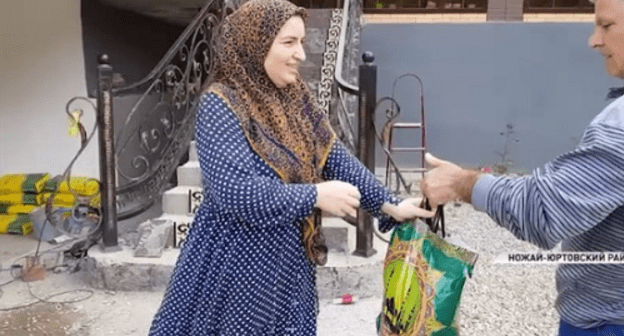 Жительница Чечни получает пакет с продуктовым набором. Кадр видеосюжета телеканала "Грозный" https://www.instagram.com/p/BioZnDRnd17/