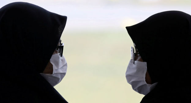Люди в медицинских масках. Фото:  REUTERS / LIM HUEY TENG
