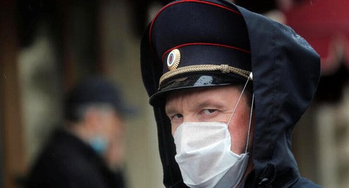 Сотрудник полиции в маске. Фото REUTERS/Maxim Shemetov Сотрудник полиции в маске. Фото REUTERS/Maxim Shemetov