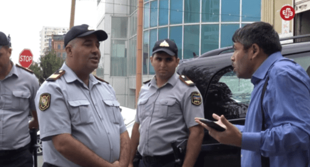 Журналист Тезехан Мираламли спорит с полицейскими, 11 сентября 2019 года. Кадр видео https://www.facebook.com/MeydanTelevision/videos/671447066668670/?v=671447066668670