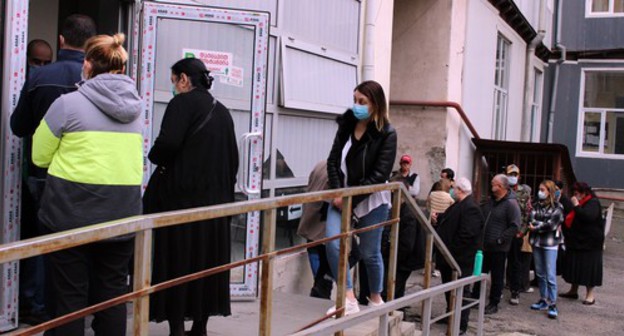 Начало очереди на избирательный участок, другая часть стоит в проеме выхода со двора на улицу, 31 октября 2020 г. Фото Инны Кукуджановой для "Кавказского узла"
