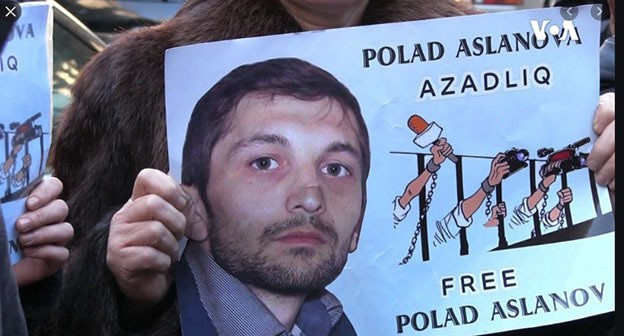 Участник акции держит плакат  изображением Полада Асланова. Скриншот видео "
Amerikanın Səsi" https://www.youtube.com/watch?v=MeItCVwfF20