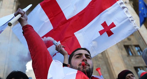 Сторонник "Единого национального движения" держит флаг во время митинга. Февраль 2021 г. Фото: REUTERS/Ираклий Геденидзе Сторонник "Единого национального движения" держит флаг во время митинга. Февраль 2021 г. Фото: REUTERS/Ираклий Геденидзе