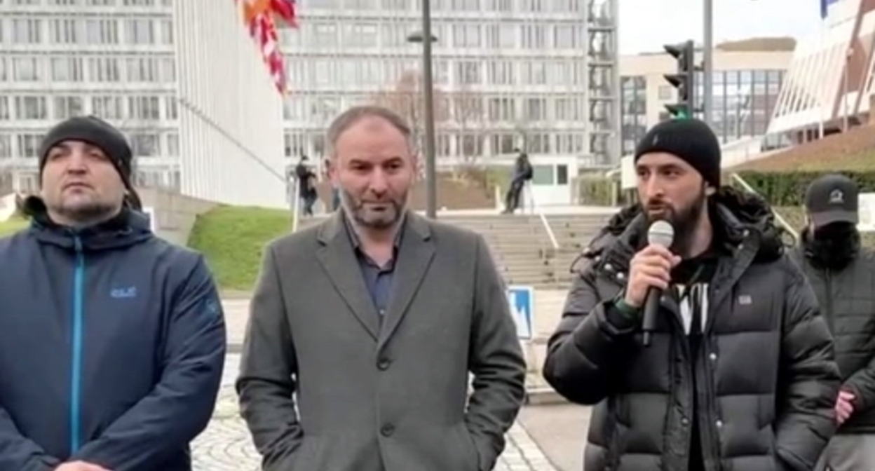 Тумсо Абдурахманов (справа) выступает на митинге в Страсбурге 8 января 2022 года. Скриншот из видео, опубликованного в Telegram-канале Тумсо