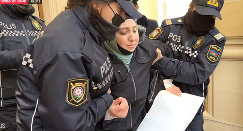 Сотрудники полиции и супруга осужденного журналиста Полада Асланова у здания Генпрокуратуры Азербайджана. Кадр видео прямого эфира https://www.facebook.com/MeydanTelevision/videos/2434785536658608