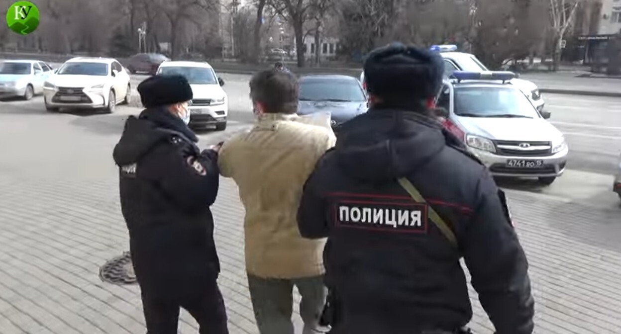 Полицейские в Волгограде уводят с пикета Евгения Вильникова, который требовал прекращения военного конфликта на Украине. Стоп-кадр из видео "Кавказского узла" https://www.youtube.com/watch?v=DS6i7jXjTKk Полицейские в Волгограде уводят с пикета Евгения Вильникова, который требовал прекращения военного конфликта на Украине. Стоп-кадр из видео "Кавказского узла" https://www.youtube.com/watch?v=DS6i7jXjTKk