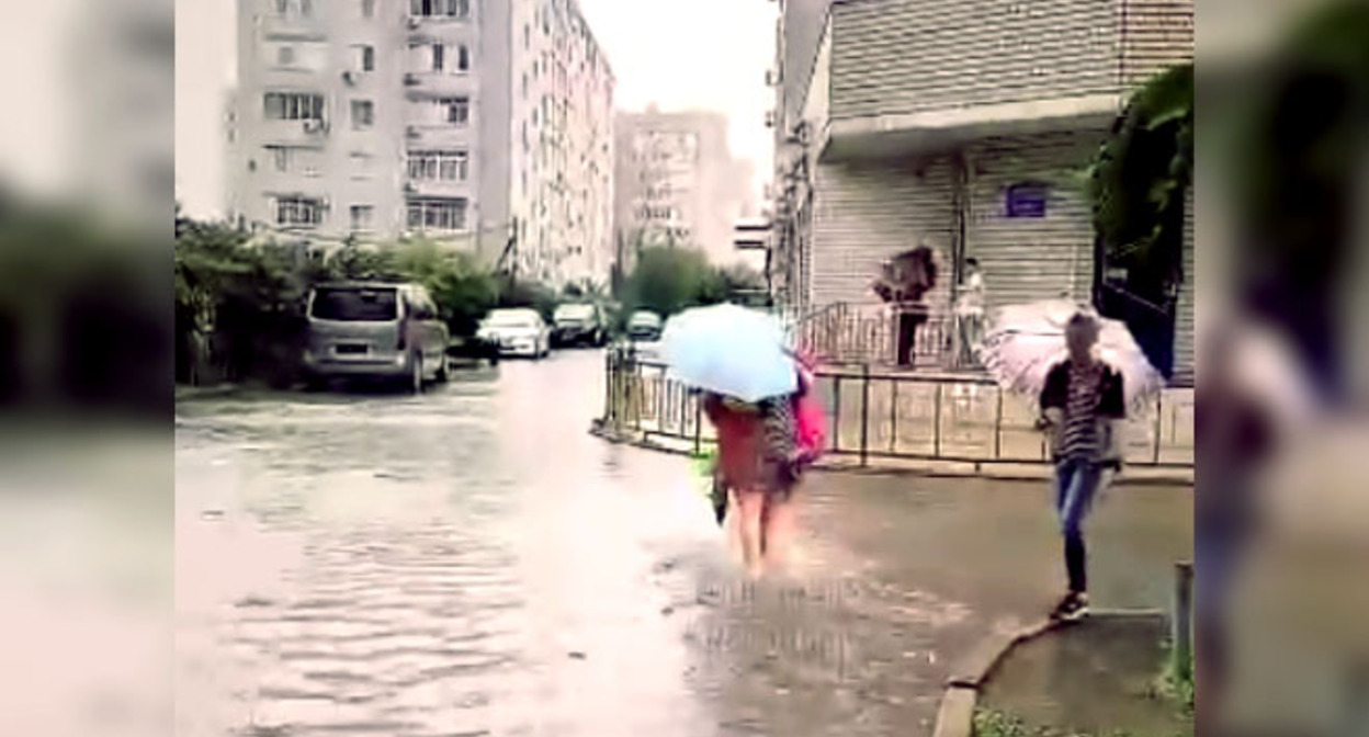 Жительница Краснодара переходит подтопленную улицу. Стоп-кадр из видео на странице https://vk.com/wall-33025155_10315557 Жительница Краснодара переходит подтопленную улицу. Стоп-кадр из видео на странице https://vk.com/wall-33025155_10315557