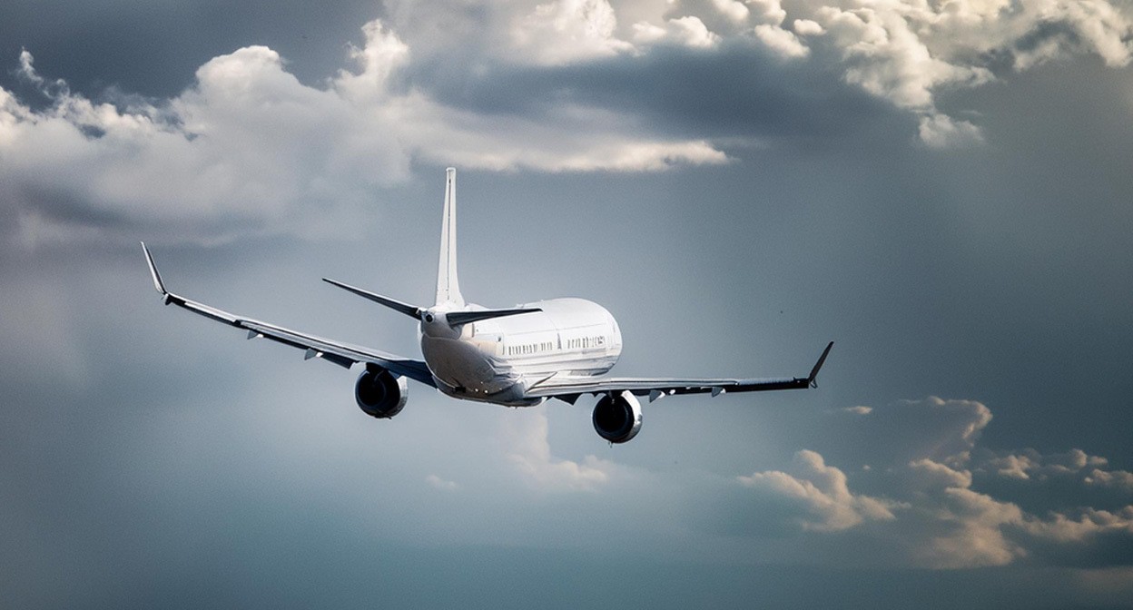 Самолет летит в небе. Иллюстрация создана «Кавказским узлом» с помощью ИИ в программе Photoshop
