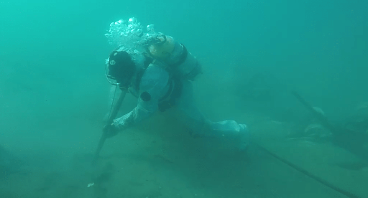 Водолаз собирает мазут на дне моря у Джемете. Стоп-кадр видео оперштаба Краснодарского края от 21.03.25, https://t.me/opershtab23/12866.