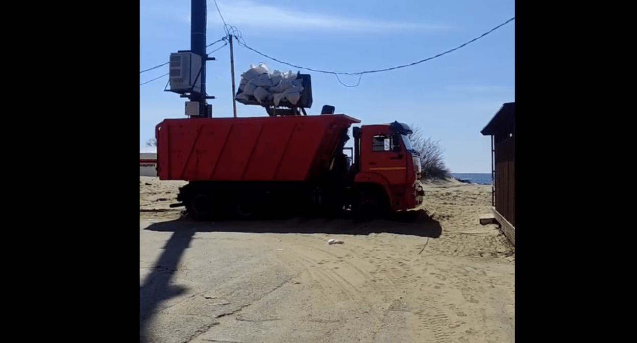 Мешки с песком грузят в самосвал. Скриншот фото из Telegram-канала Юрия Озаровского от 24.03.25, https://t.me/c/1482614470/1190360.
