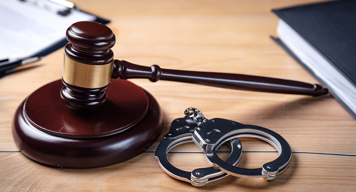 Наручники и молоток судьи. Иллюстрация создана «Кавказским узлом» с помощью ИИ в программе Photoshop