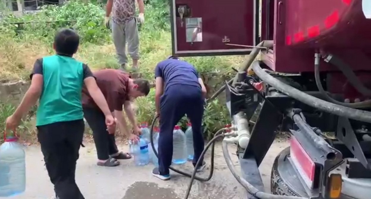 Люди набирают воду из водовоза. Кадр видео из телеграм-канала администрации Буйнакска https://t.me/gorodbuynaksk/8092