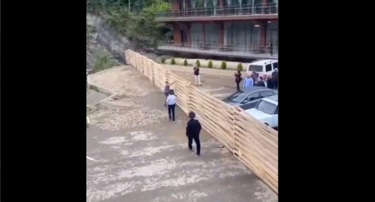 Местный житель пытается сломать забор у Ханагского водопада. Скриншот с видео телеграм-канала "Голос Дагестана" https://t.me/golosdagestana05/15367