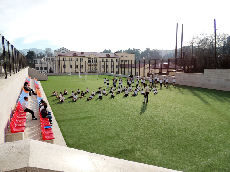 Летняя спортивная площадка. Два шестых класса проходят урок физкультуры.