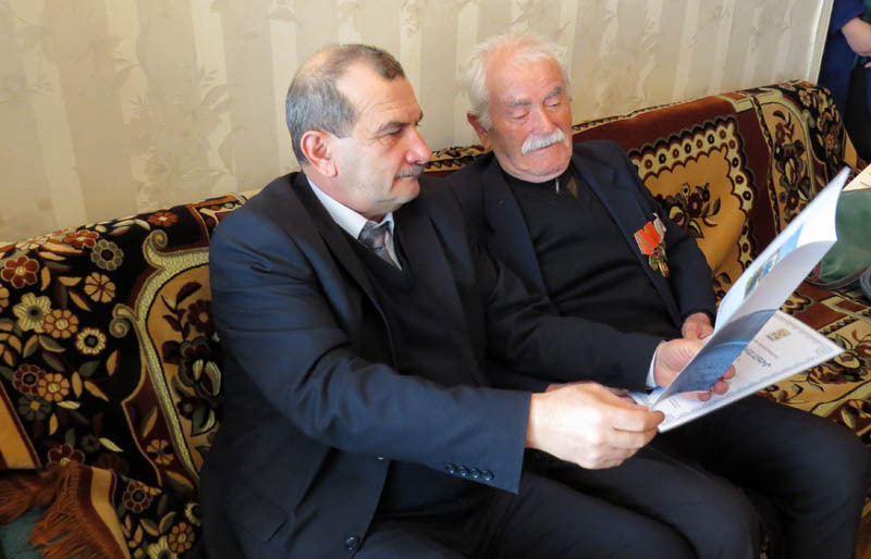 Директор Водоканала Аветисян Мартин показывает деду Завену Грамоту.