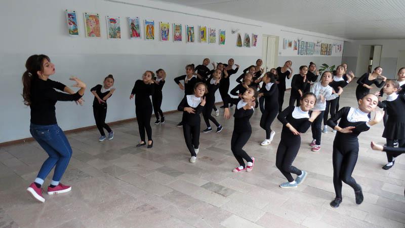 Педагог Лилит Григорян проводит разминку с детьми танцевального кружка.