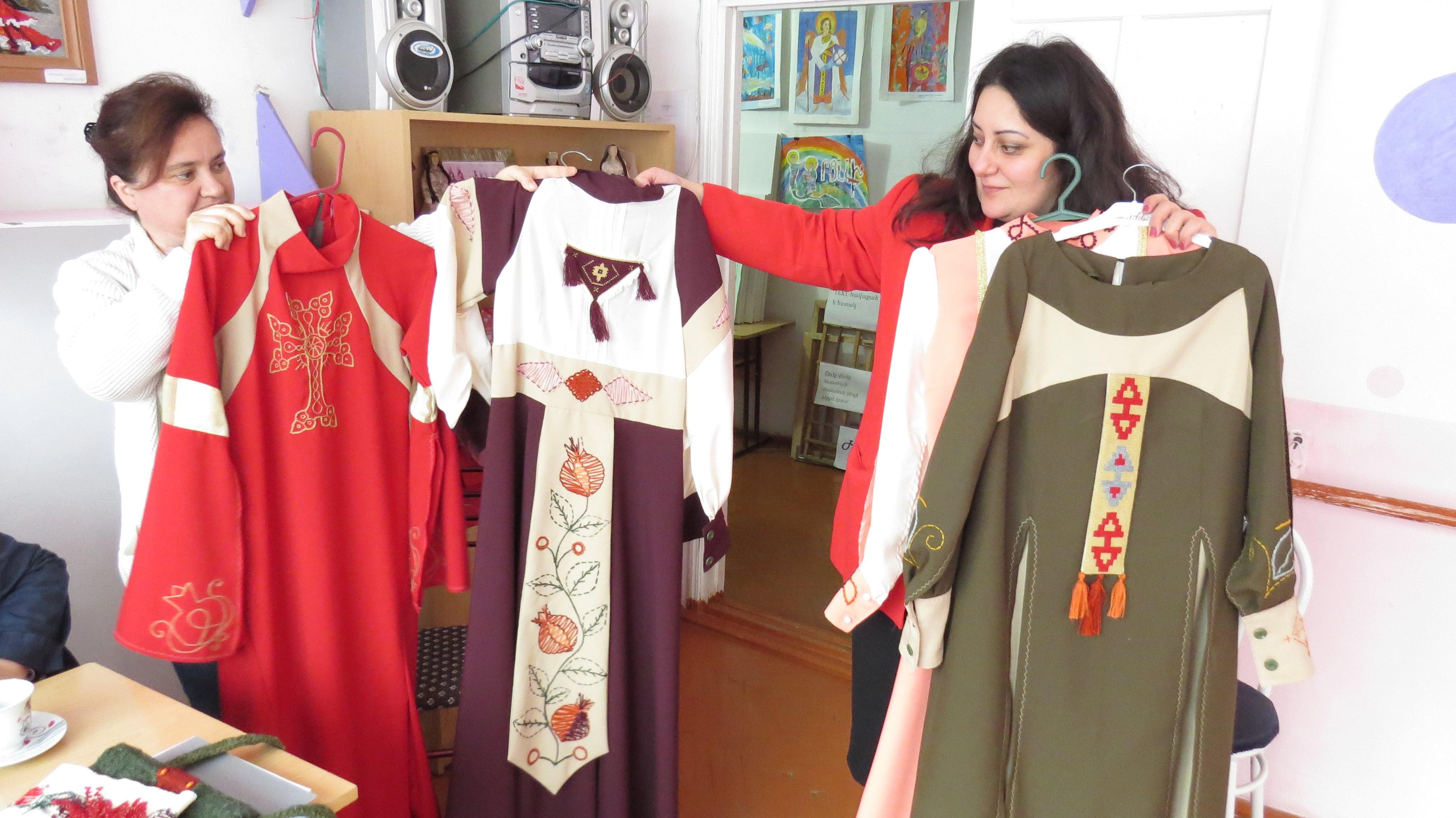 Мануш Нерсесян (слева), сотрудница центра и Надя  и Надежда Саркисян, замдиректора показывают платья, сшитые руками учениц центра.