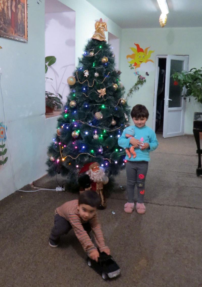 Тигранчик и Тая, брат и сестра у ёлки.